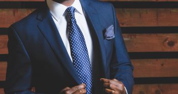 Comment faire un nœud de cravate ? Buste d'un homme en costume bleu avec cravate bleue à pois blancs