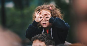 Que faire lors d’un week-end en famille à Nantes ? Petit fille assise sur les épaules de son père en train d'oberser la foule