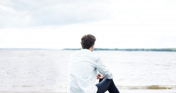 Combien de temps pour se remettre d’une rupture ? Homme assis sur la plage, qui regarde l'horizon