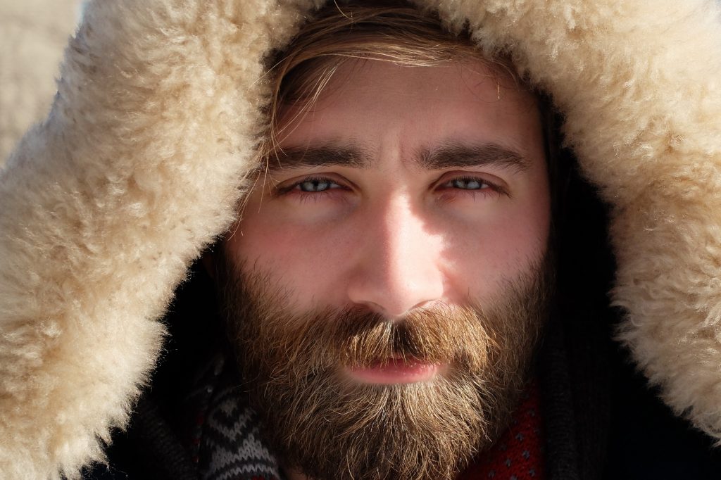 Gros plan sur le visage d'un homme, avec une barbe châtain aux reflets roux et blonds