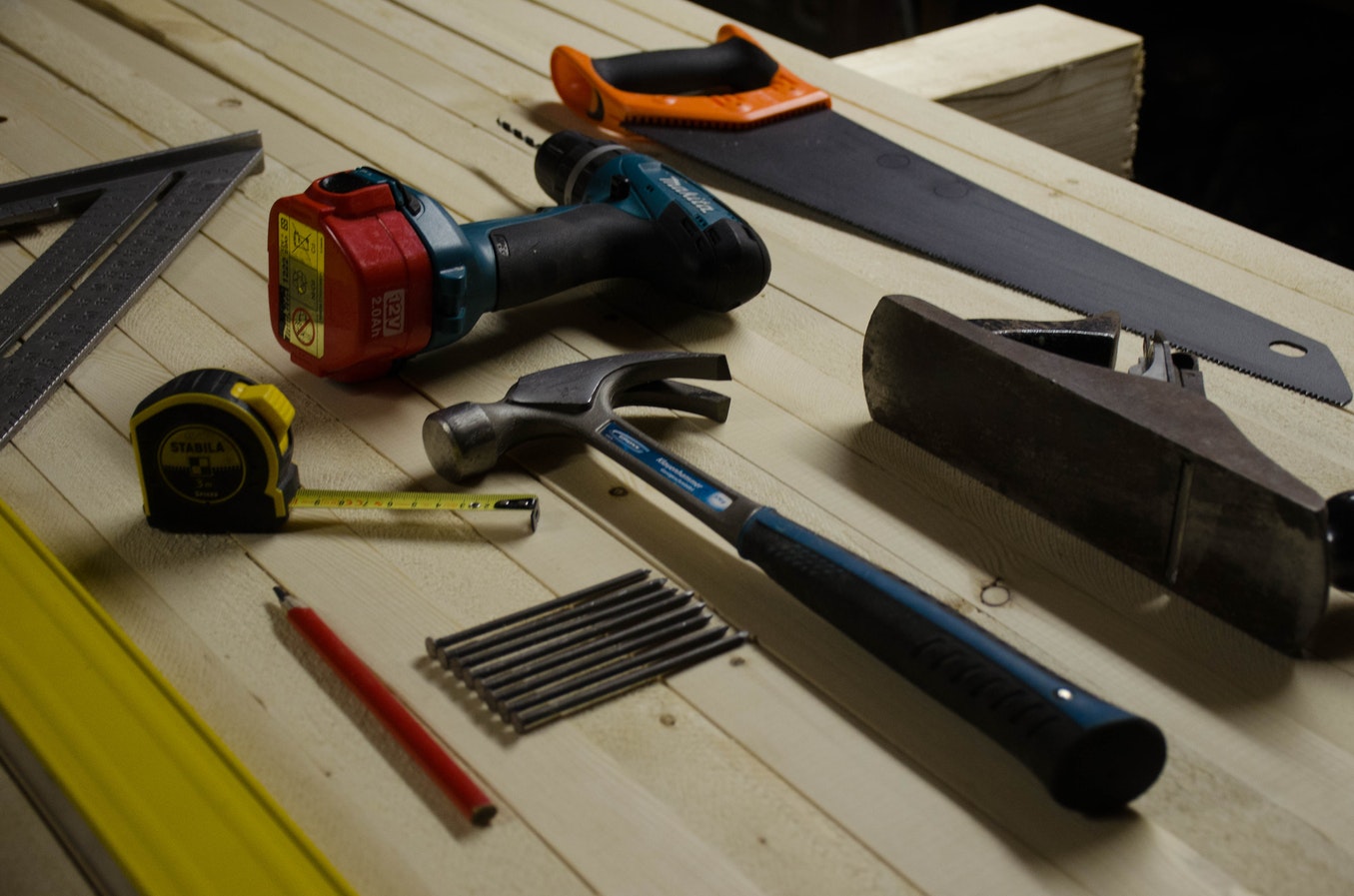 Outils à main et outils électroportatifs posés dans un atelier de bricolage