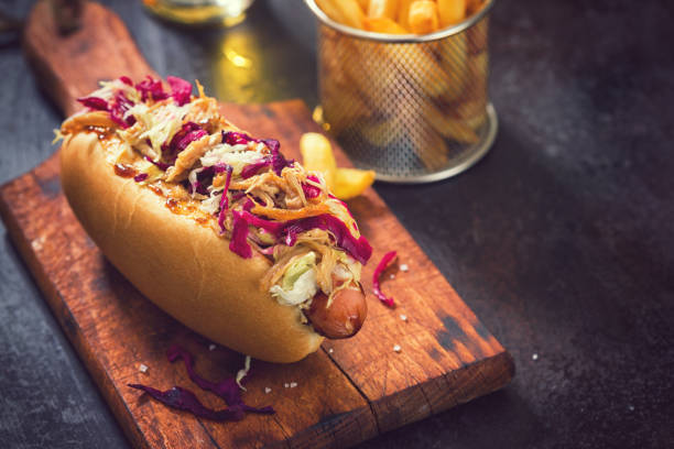 Hot dog coleslaw sur planche en bois avec pot de frites