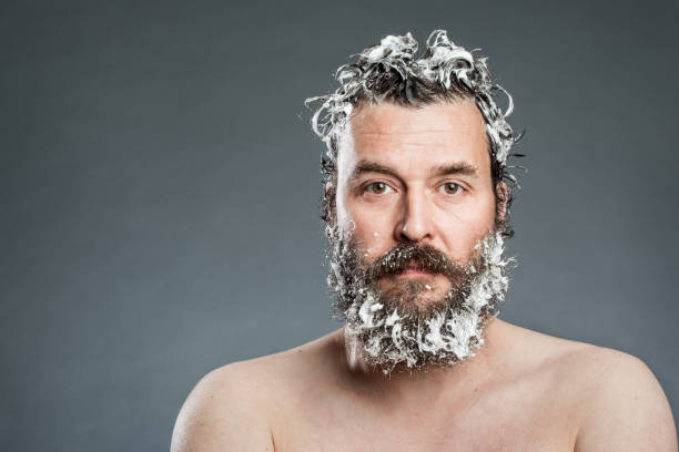 Homme avec shampoing sur les cheveux et la barbe