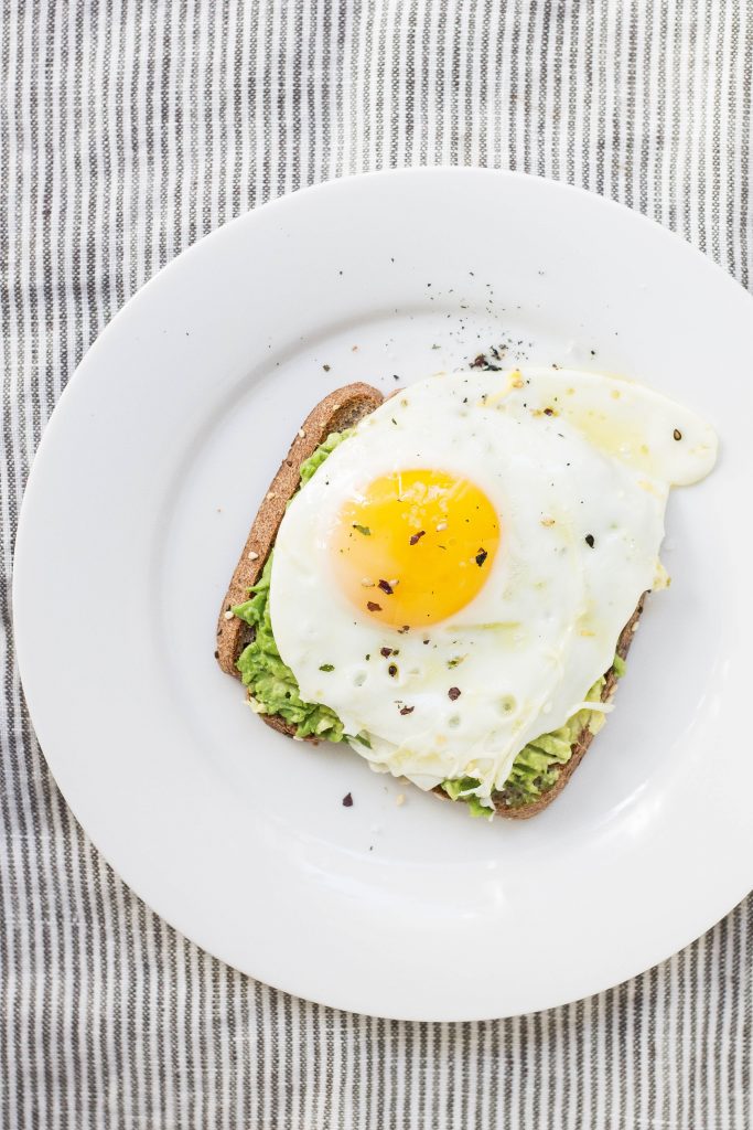 Oeuf au plat sur une tranche de pain complet avec du guacamole