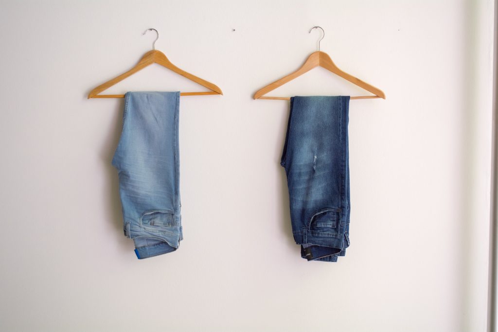 Jeans homme suspendus à des cintres