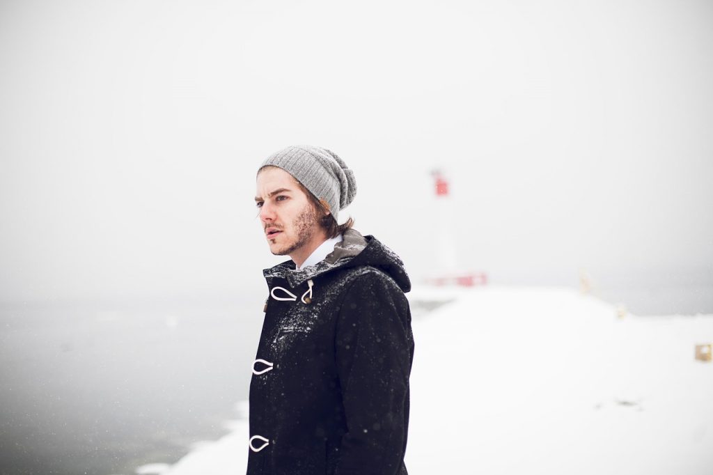 homme qui porte un bonnet et un manteau d'hiver